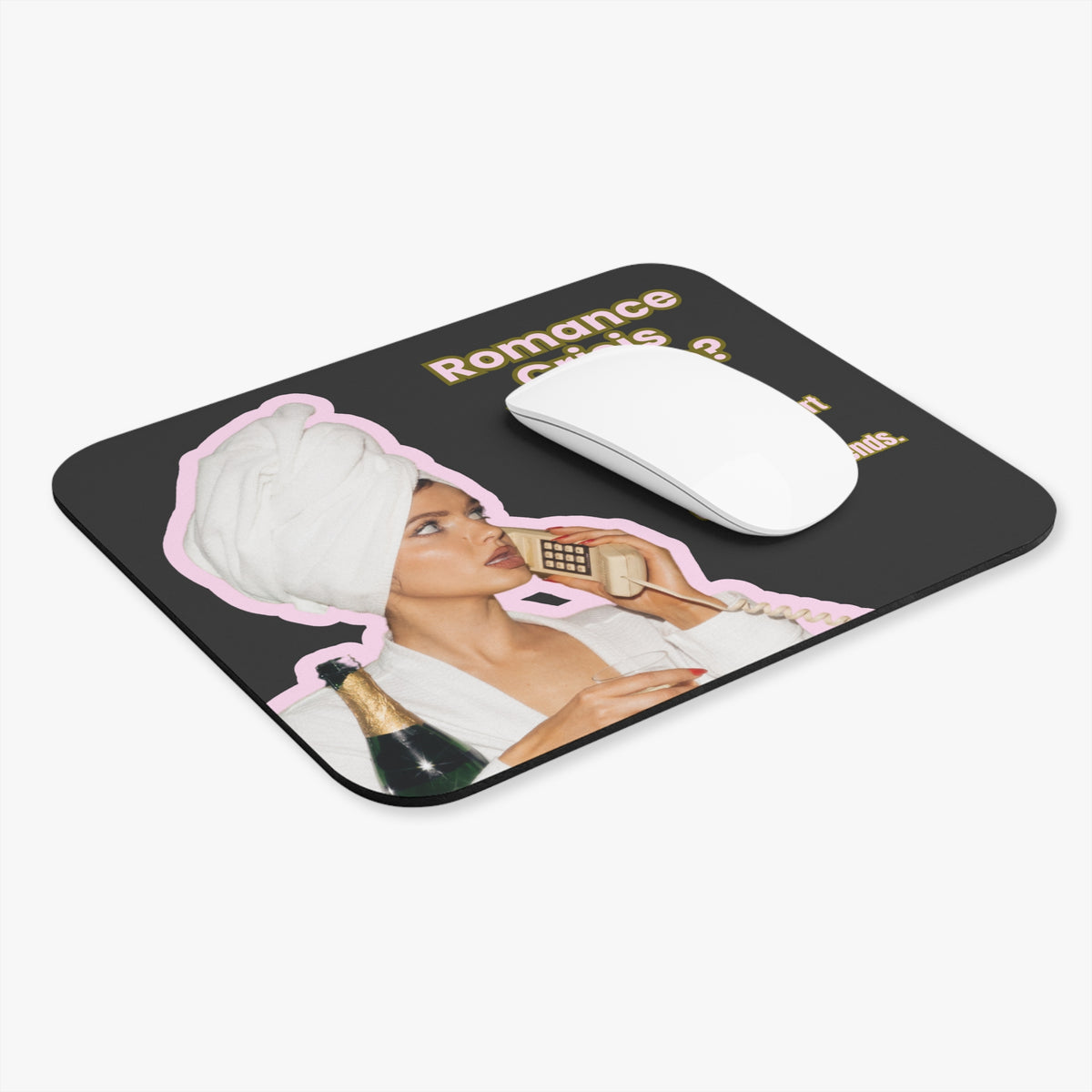 A rectangular black mousepad with rounded corners, featuring a retro-style graphic of a woman in a white robe and turban wrapping a phone, with the text 'Romance Crisiis Hotline. I'd like to report a shortage of book boyfriends.