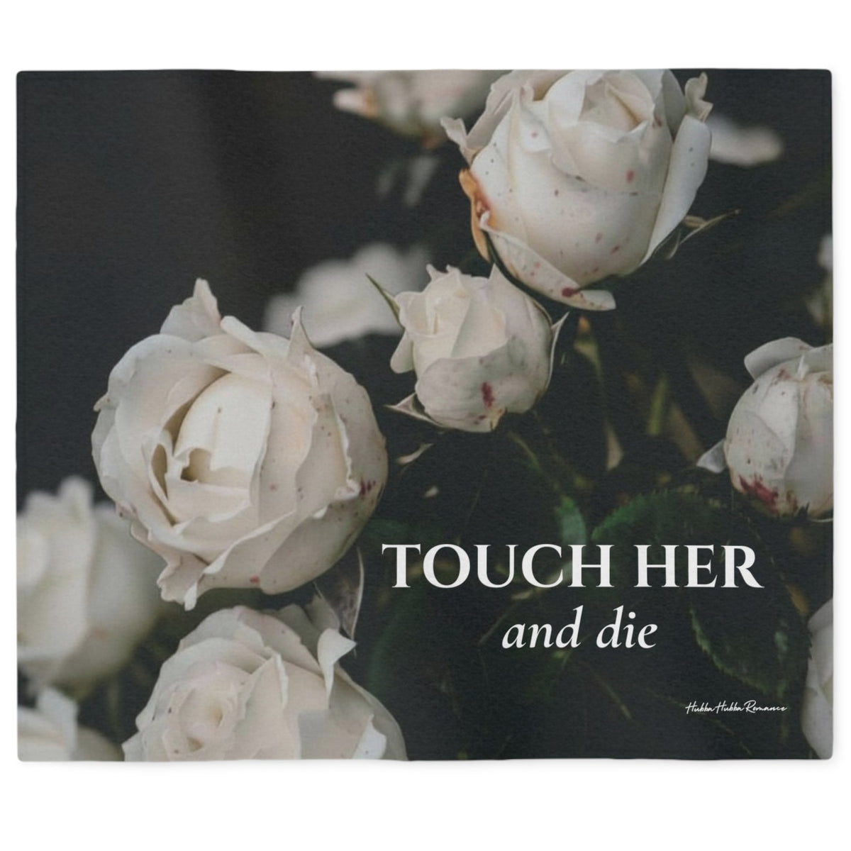 A sweatshirt blanket featuring a close-up image of blood spattered white roses against a dark background, with the text 'TOUCH HER and die' printed in white serif  lettering. 