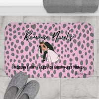 The bath mat is displayed next to a tub with a pair of slippers for size context.
