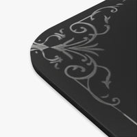 A close-up of the mousepad featuring a light gray ornate scroll pattern on a dark gray background.