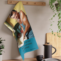 The towel is displayed on a wall hook in a kitchen setting.
