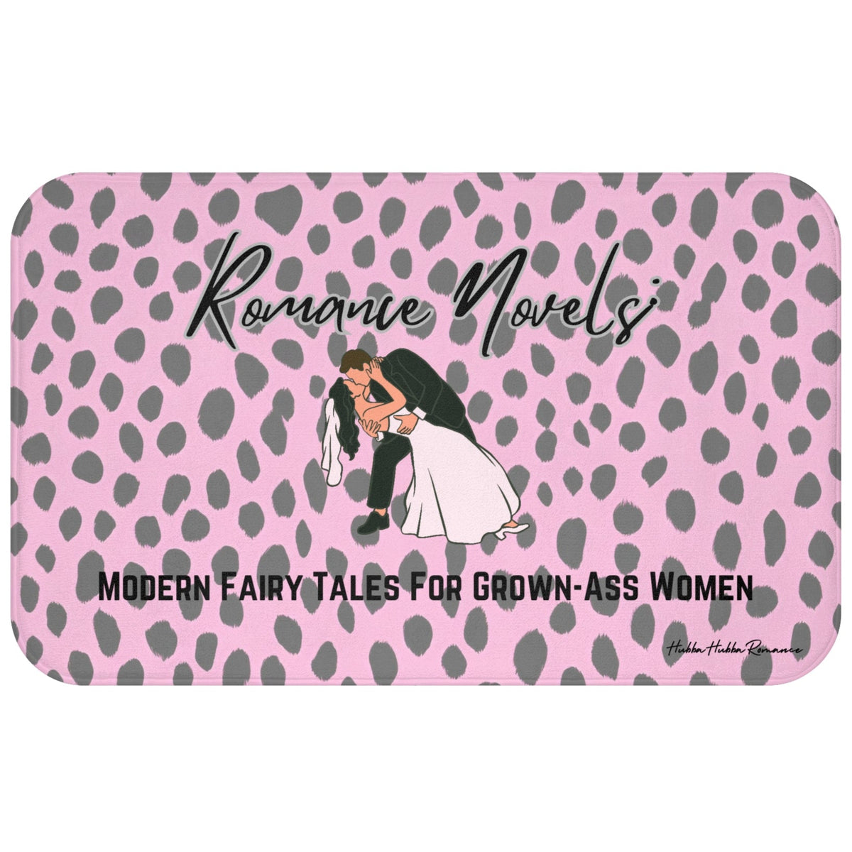 ADA Product Description:
This bath mat features a light pink background with a gray leopard print pattern. Centered near the top is the text “Romance Novels” in a black script font. Below that is an illustrated image of a groom dipping a bride into a dramatic kiss. At the bottom, bold black text reads: “Modern Fairy Tales For Grown-Ass Women.” The mat is soft and absorbent, combining playful design with a bold celebration of the romance genre. This is the larger version.
