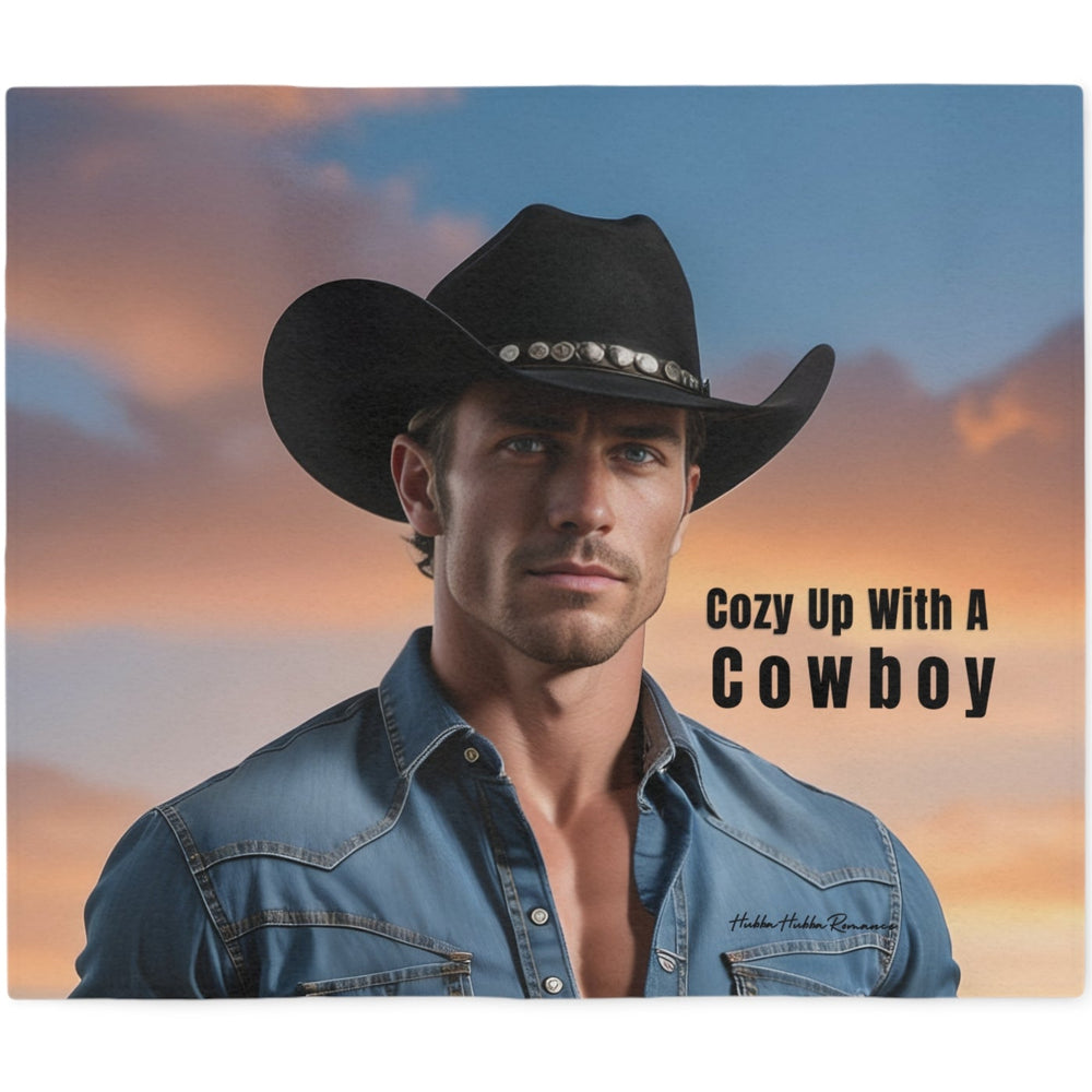 Western romance sweatshirt blanket featuring a handsome cowboy in a black hat and denim shirt with the phrase "Cozy Up With a Cowboy" printed over a warm sunset landscape. Soft blanket designed for western romance readers.