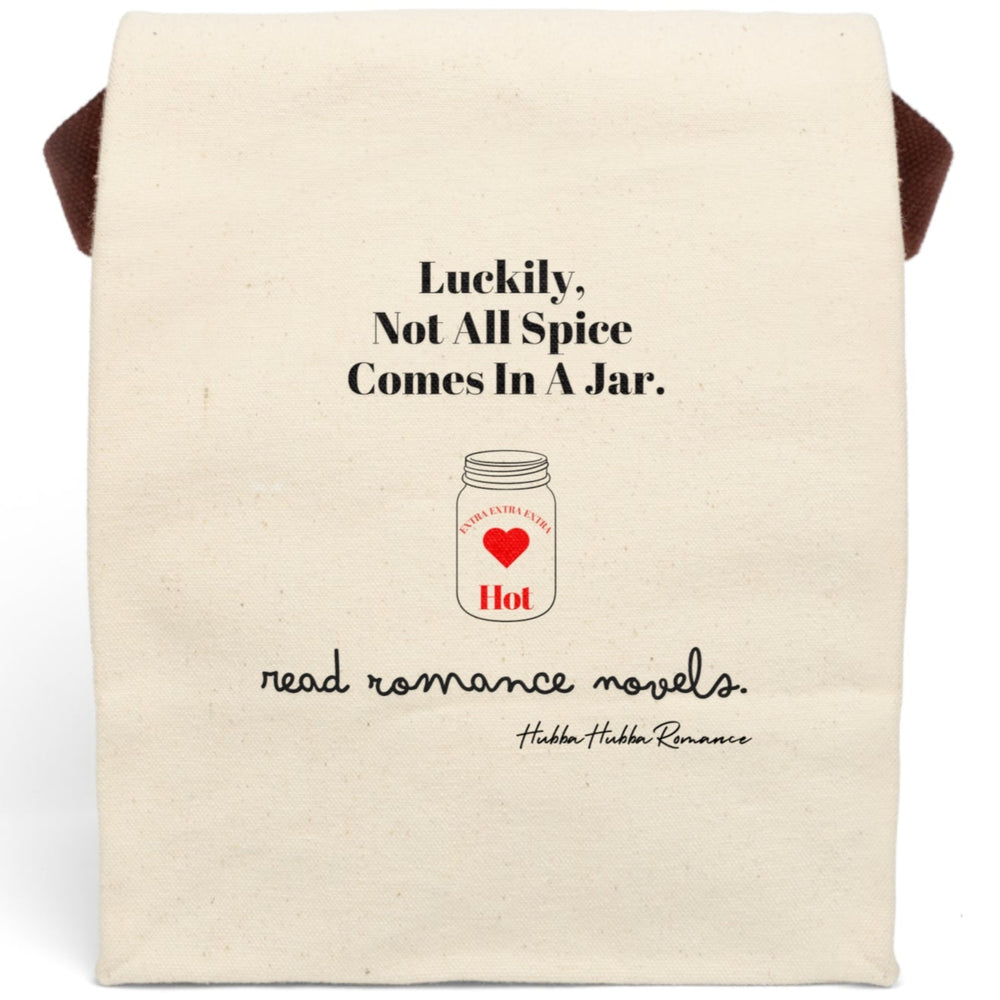 This canvas lunch bag features a natural canvas background with bold black typography. At the top, large black text reads: “Luckily, Not All Spice Comes In A Jar.” Below is a simple drawing of a mason jar with a red heart in the center. At the top of the jar, curved text reads: “Extra Extra Extra,” and beneath the heart, the word “Hot” appears in red. At the bottom of the design, cursive black script reads: “read romance novels.” The bag includes a velcro closing and canvas handle for carrying.
