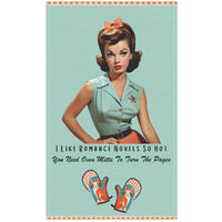 The kitchen towel features a vintage-inspired illustration of a glamorous woman from the 1950s, sporting a stylish updo and a mint green camp shirt, black belt, and an orange skirt, accompanied by text that reads, "I Like Romance Novels So Hot You Need Oven Mitts to Turn the Pages." Below the text are two whimsical oven mitts with playful cats and orange polka-dot details. The design combines retro charm and humor, appealing to fans of steamy romance novels. 
