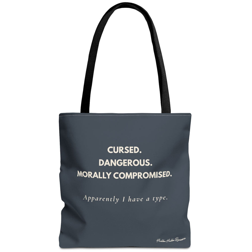Dark gray romance reader tote bag reading Cursed Dangerous Morally Compromised and Apparently I have a type in cream colored font.
