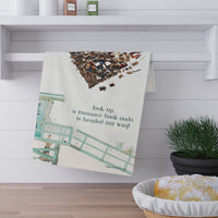 The towel is displayed by folding it over a towel bar underneath a shelf.