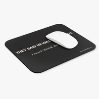 Black mouse pad with cream text and a white mouse on a white background