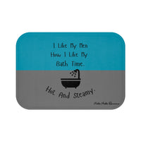 This bath mat features two background colors: teal on the top half and gray on the bottom half. The top half includes playful black text that reads: “I Like My Men How I Like My Bath Time.” Centered in the lower half is a black graphic of a vintage-style bathtub with a shower head spraying water. Below the tub, curved black text reads: “Hot And Steamy.” The mat is soft, absorbent, and designed for romance readers with a cheeky sense of humor.
This is the smaller sized mat.