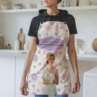 Woman in kitchen wearing white apron with pink and purple polka dots and black straps, vintage-style woman in mint green dress with pearls and gloves, text reads “I like my recipes simple and my book boyfriends complicated” inside purple speech bubble.