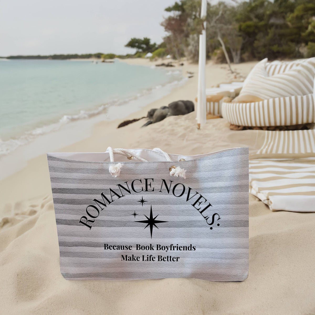 The weekender bag is displayed standing upright on the beach next to beach towels.
