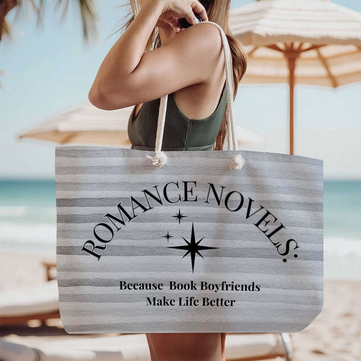 The tote bag is being modeled by a woman in a green tank top, standing on the beach, wearing it over her shoulder.

