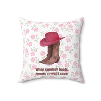 This 18 inch square pillow features a pair of brown leather cowboy boots with intricate stitching and metal accents, topped with a red cowboy hat with black stitched detailing. The background is soft white with a delicate pink floral pattern. Below the boots and hat, the bold brown text reads: "When cowboy boots meets cowgirl sass!" The design combines Western charm with a playful, feminine flair.