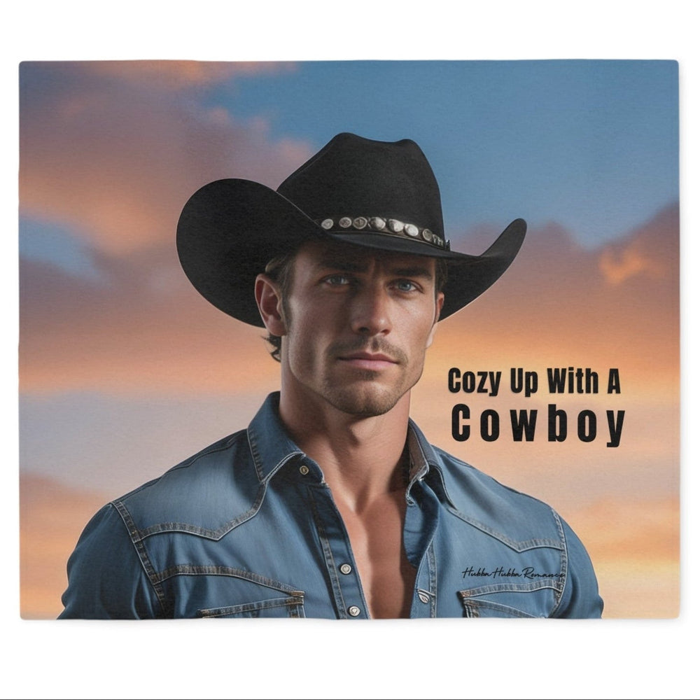 Western romance sweatshirt blanket featuring a handsome cowboy in a black hat and denim shirt with the phrase "Cozy Up With a Cowboy" printed over a warm sunset landscape. Soft blanket designed for western romance readers.