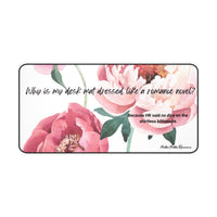  A desk mat featuring soft watercolor-style peonies in shades of pink and blush. Green leaves frame the florals on a white background. The text reads, “Why is my desk mat dressed like a romance novel?” followed by “Simple. Because HR said no dice on the shirtless billionaire.”