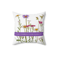 A 16-inch pillow that features a collection of wildflowers, including daisies, pink carnations, and a prominent purple aster, set against a clean white background. A horizontal purple banner stretches across the center, displaying the phrase "I'm Just a Wildflower in the Garden of Love." in white text. The design has a soft, romantic feel, evoking themes of individuality, natural beauty, and love.