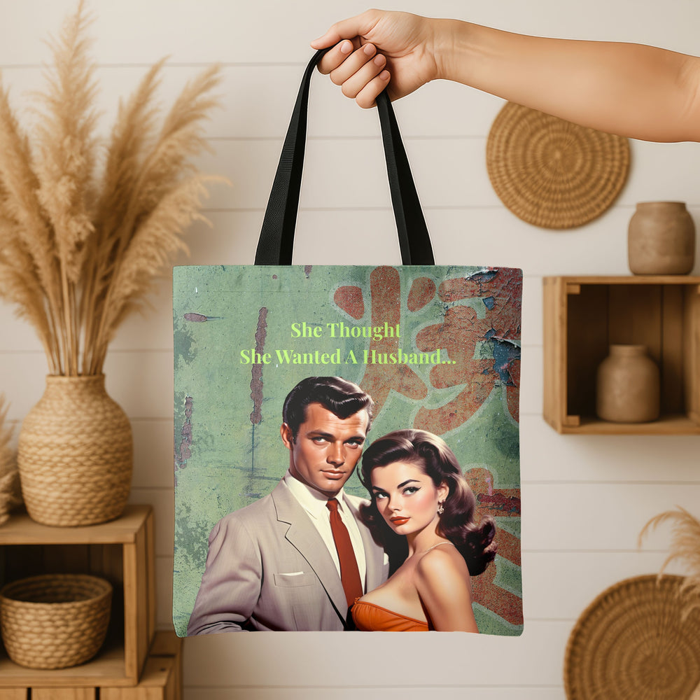 Person holding tote bag with distressed green background, retro couple illustration, and text: “She Thought She Wanted A Husband…”; baskets and vases for decor.