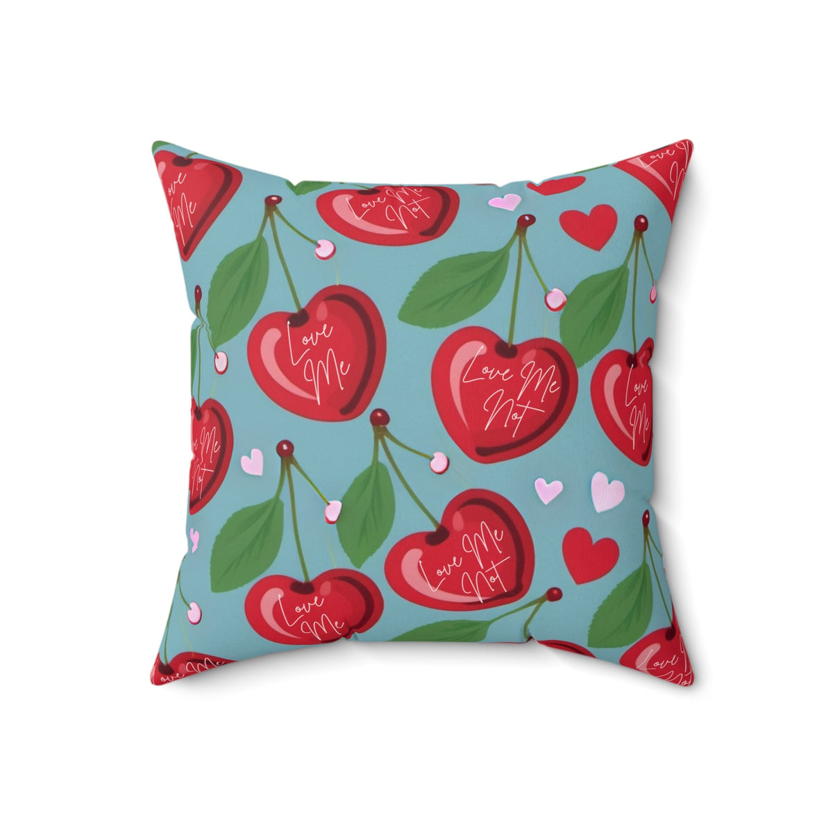 A 18-inch pillow features a playful pattern of heart-shaped cherries with green leaves and stems against a light blue background. Scattered among the cherries are small red and pink hearts. Each cherry is adorned with elegant white cursive text that alternates between "Love Me" and "Love Me Not," evoking the classic game of romantic uncertainty. The whimsical, romantic design combines a sweet aesthetic with a touch of flirtatious fun.