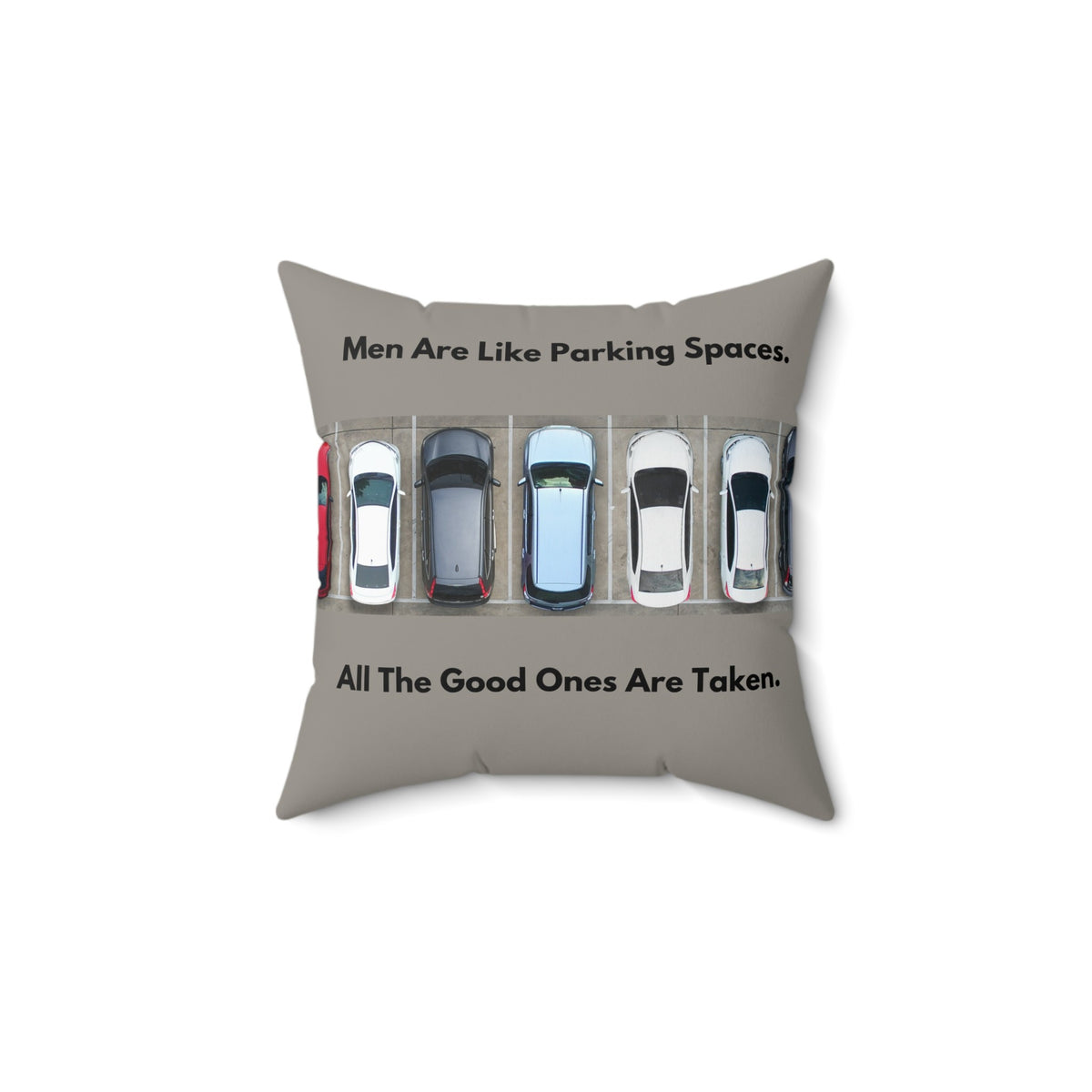 A 14-inch pillow features an overhead view of a row of parked cars in a parking lot. Above the image, bold black text reads: "Men Are Like Parking Spaces." Below the image, matching text continues: "All The Good Ones Are Taken." The background is a muted grayish-green, allowing the text and image to stand out. The design is playful and sarcastic, making a humorous comparison between dating and the struggle to find an available parking spot. 