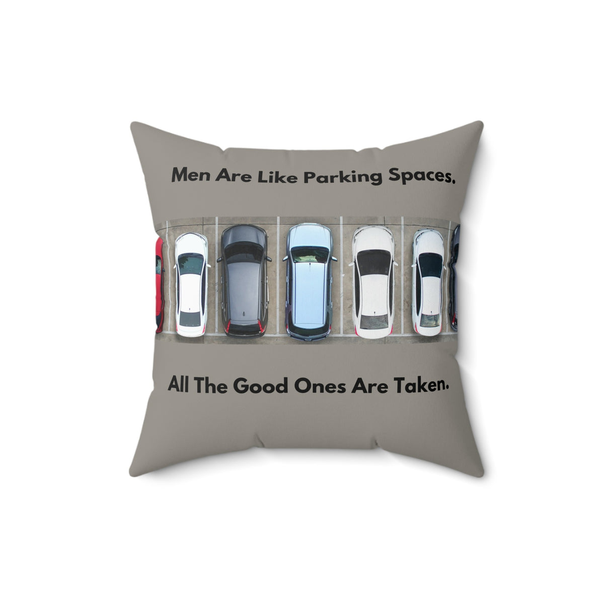A 16-inch pillow features an overhead view of a row of parked cars in a parking lot. Above the image, bold black text reads: "Men Are Like Parking Spaces." Below the image, matching text continues: "All The Good Ones Are Taken." The background is a muted grayish-green, allowing the text and image to stand out. The design is playful and sarcastic, making a humorous comparison between dating and the struggle to find an available parking spot. 
