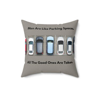 A 16-inch pillow features an overhead view of a row of parked cars in a parking lot. Above the image, bold black text reads: "Men Are Like Parking Spaces." Below the image, matching text continues: "All The Good Ones Are Taken." The background is a muted grayish-green, allowing the text and image to stand out. The design is playful and sarcastic, making a humorous comparison between dating and the struggle to find an available parking spot. 