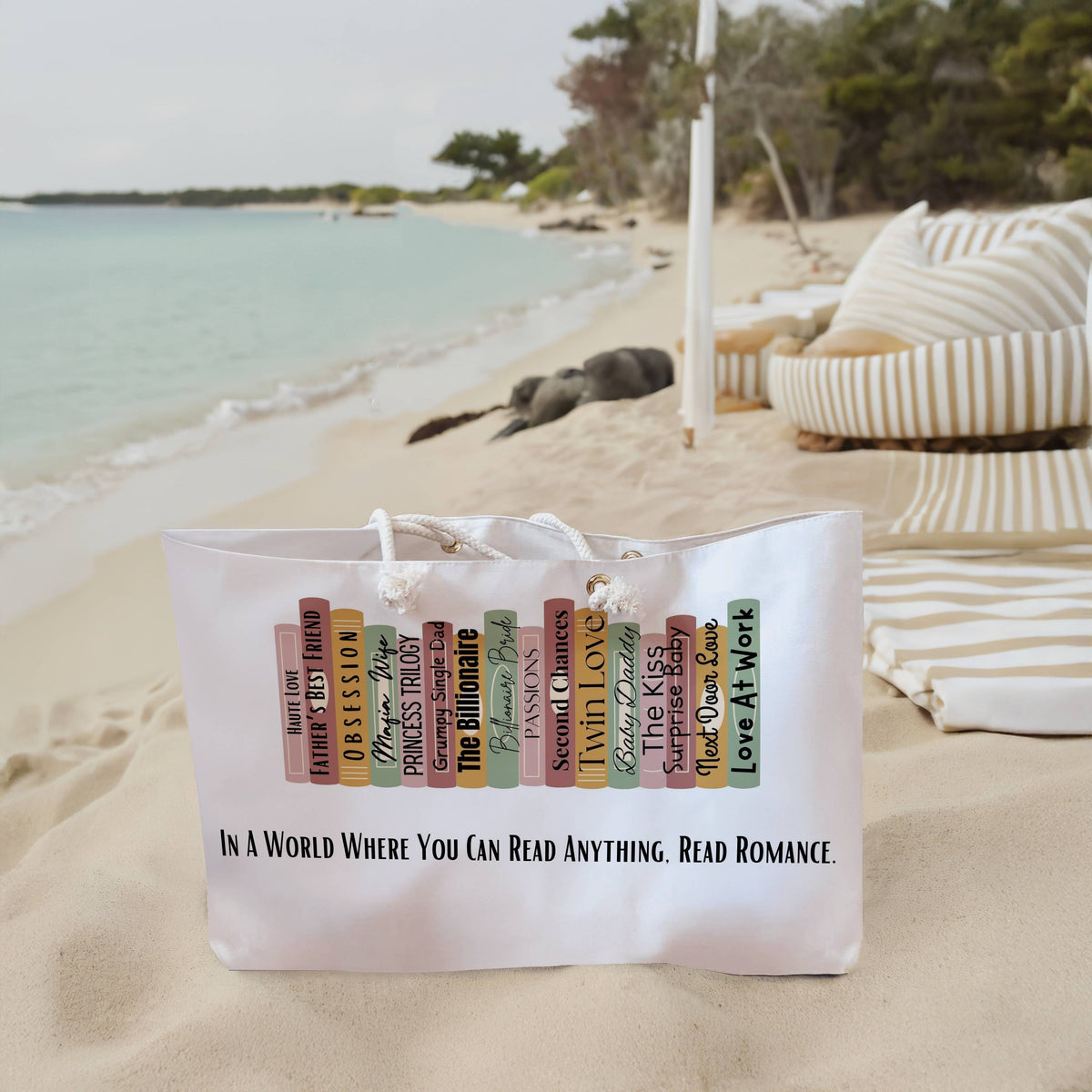 The weekender bag is displayed standing upright on the beach next to beach towels.
