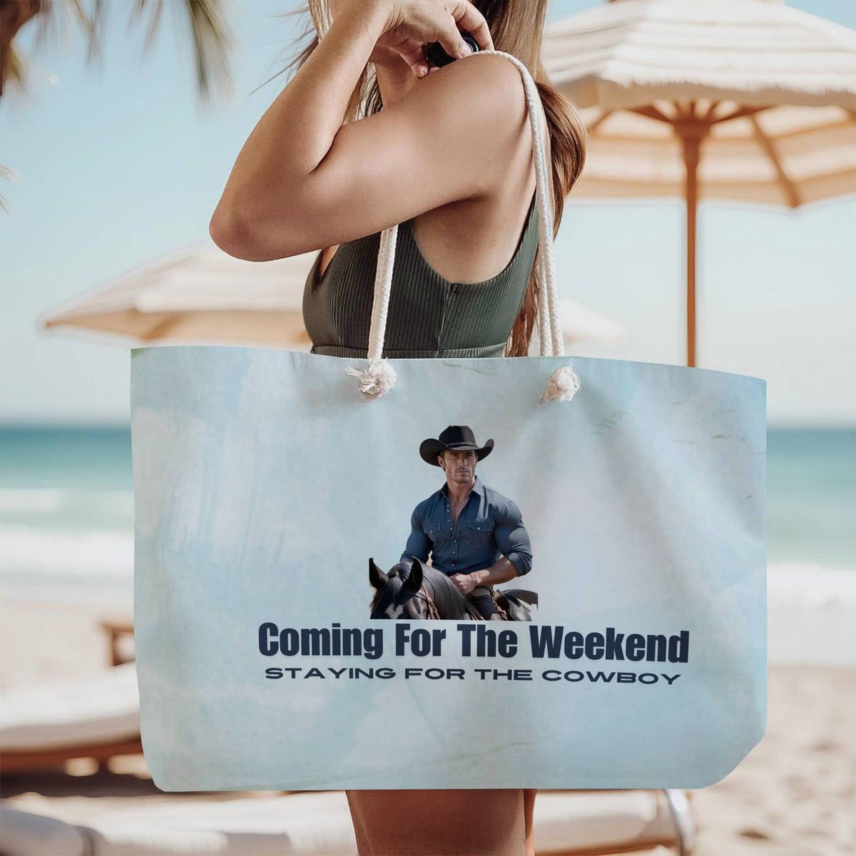 The tote bag is being modeled by a woman in a green tank top, standing on the beach, wearing it over her shoulder.

