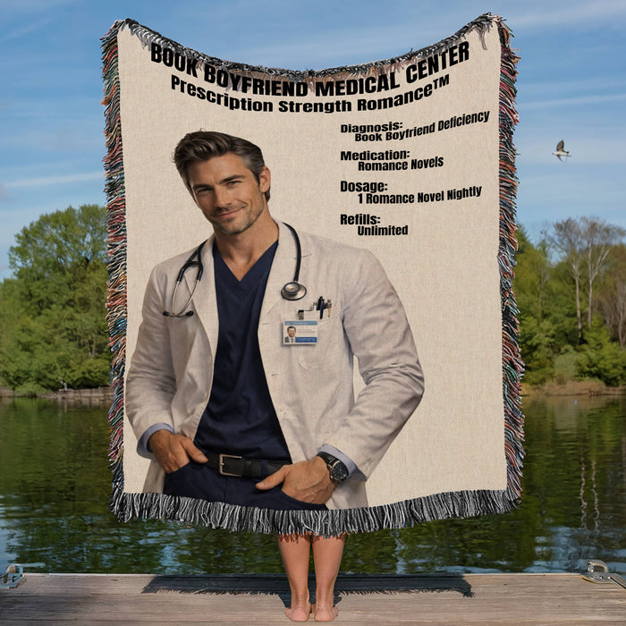 Blanket with a doctor's from the book Boyfriend Medical Center held by a person on a dock with trees and water in the background