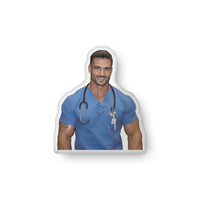 Custom-shaped book boyfriend pillow featuring a handsome medical romance hero wearing blue scrubs and a stethoscope, styled as a nurse character with a calm, confident expression. Designed for romance readers who love caregiver tropes, medical romance aesthetics, and cozy bookish home decor from Hubba Hubba Romance. Available in three sizes: 10″ × 10″, 16″ × 16″, and 22″ × 22″.