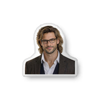 Custom-shaped decorative pillow featuring The Professor, an academic romance book boyfriend with glasses, shoulder-length hair, light stubble, and a confident expression, wearing a tailored jacket over a button-down shirt. Shown as a standalone pillow against a neutral background. This academic romance book boyfriend pillow is available in three sizes (10" x 10", 16" x 16", and 22" x 22").
