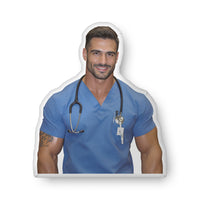 Custom-shaped book boyfriend pillow featuring a handsome medical romance hero wearing blue scrubs and a stethoscope, styled as a nurse character with a calm, confident expression. Designed for romance readers who love caregiver tropes, medical romance aesthetics, and cozy bookish home decor from Hubba Hubba Romance. Available in three sizes: 10″ × 10″, 16″ × 16″, and 22″ × 22″.