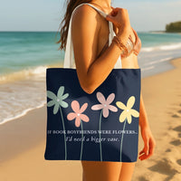 A woman on a beach carries a navy tote bag with colorful flower illustrations and the text 'IF BOOK BOYFRIENDS WERE FLOWERS...I'd need a bigger vase.