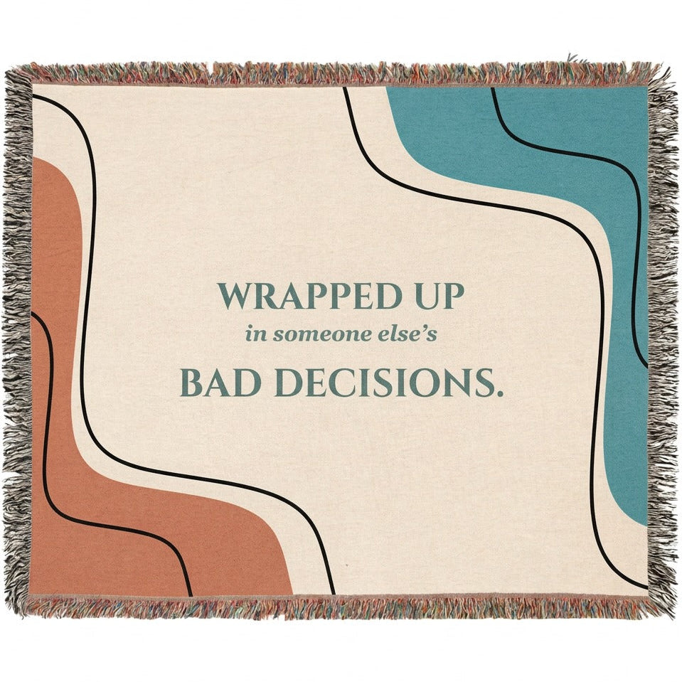 A woven cotton throw blanket with fringe edges, featuring an abstract design with wavy lines in terracotta, teal, cream, and black, with the text 'WRAPPED UP in someone else's BAD DECISIONS.' printed in teal in the center..