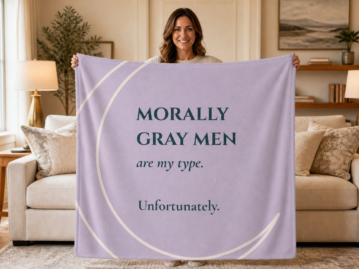 Woman holding a lavender sweatshirt blanket featuring the quote "Morally Gray Men Are My Type. Unfortunately." Cozy reading blanket for fans of dark romance books, romantasy novels, and morally gray heroes.