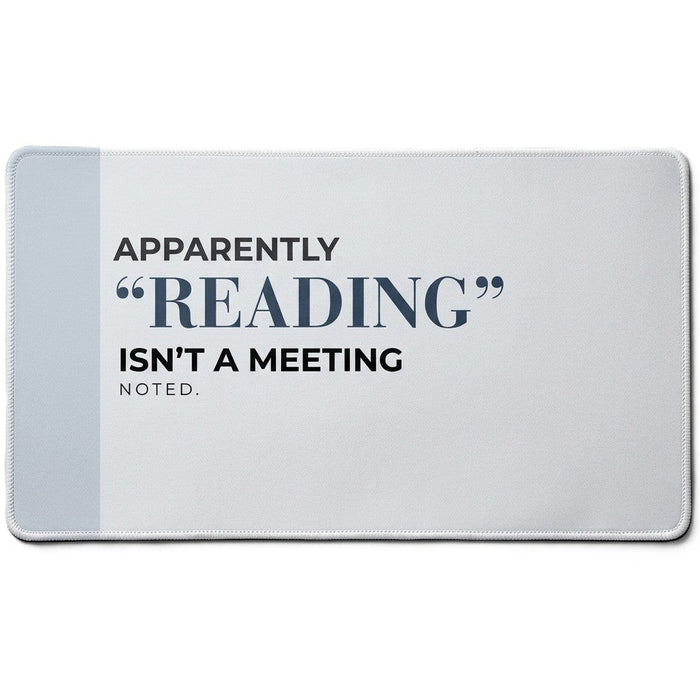 A rectangular desk mat featuring the text 'APPARENTLY "READING" ISN'T A MEETING. NOTED.' in black and navy blue lettering on a light gray background with a darker gray vertical stripe on the left side.