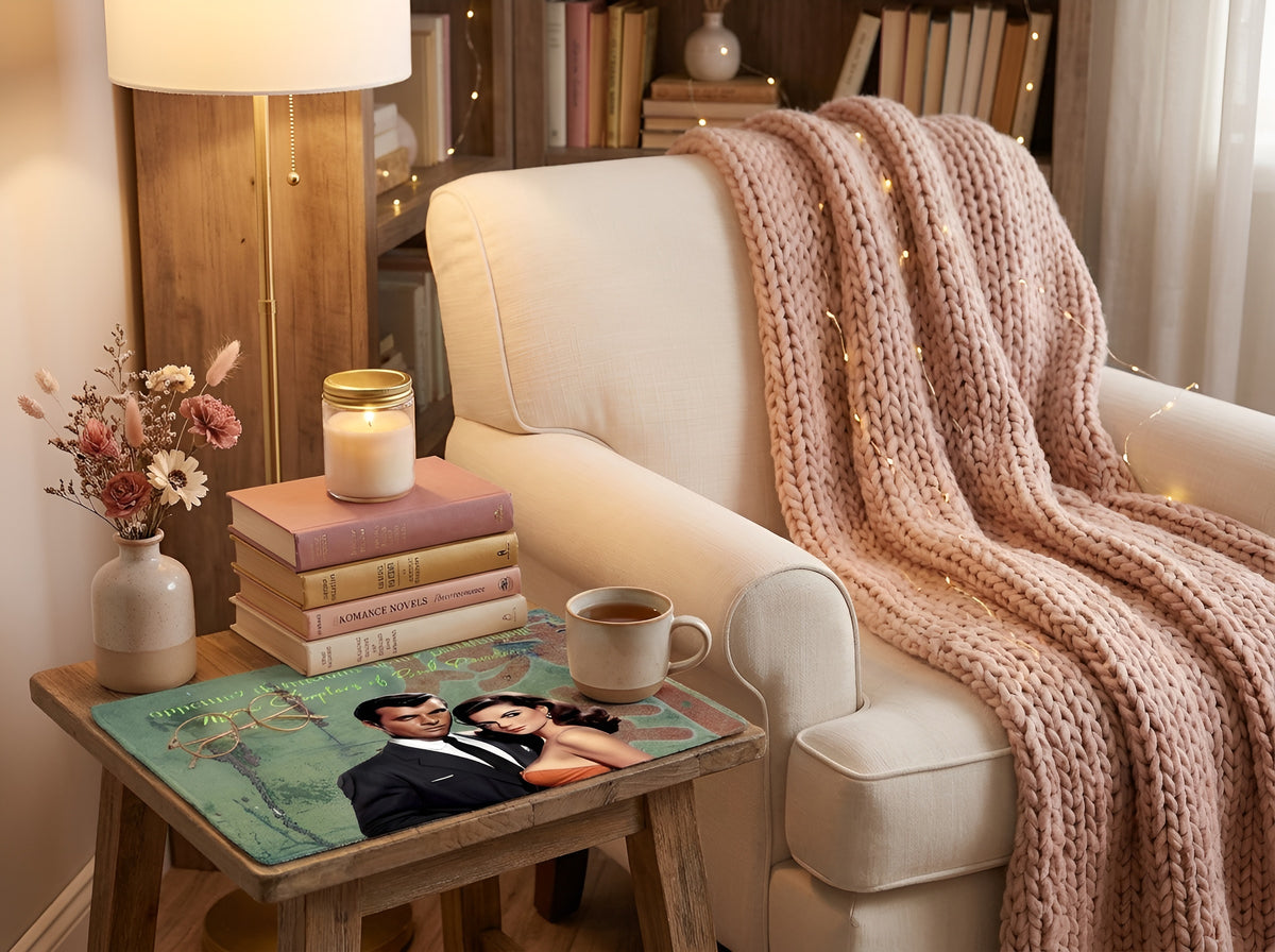 Funny cotton accent mat for romance readers styled on a cozy reading nook side table beside a chair, books, candle, coffee mug, and reading glasses. Bookish home decor featuring retro romance artwork designed for reading spaces, coffee stations, and bedside tables.